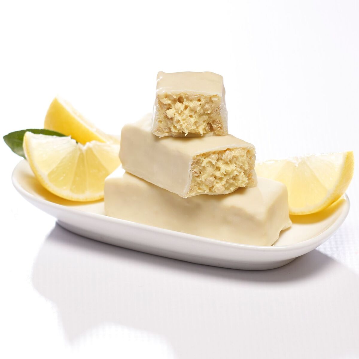 Zesty Lemon protein bars with lemon slices on white dish